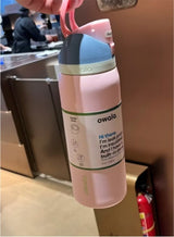 Owala FreeSip 32oz pink - held at cafe lifestyle shot